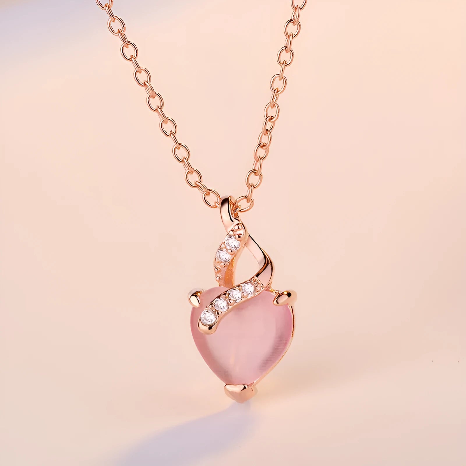 Women's rose gold heart-shaped pendant necklace with pink crystal centre on cross chain