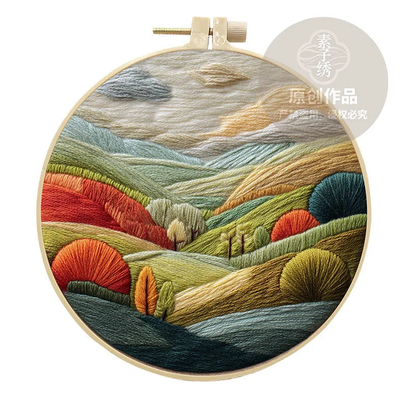 Complete DIY embroidery kit with 15cm bamboo frame, pre-printed landscape fabric, threads, and needles laid out.