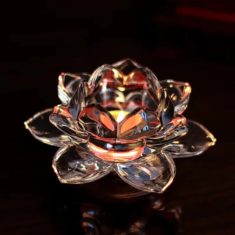 Glass lotus-shaped aromatherapy candle cup on a table.
