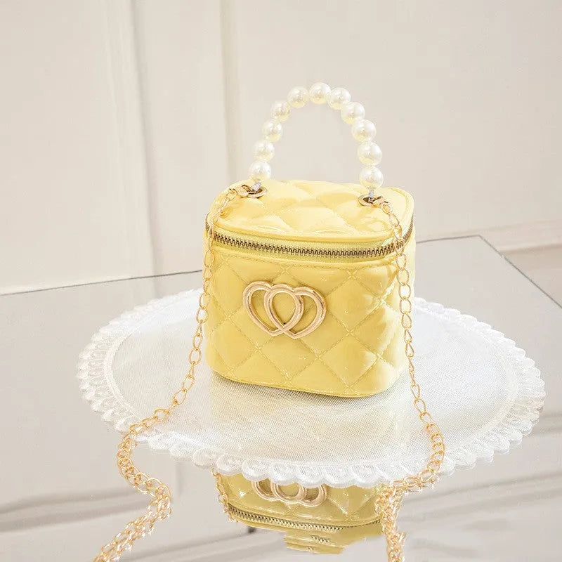 White PVC women's bucket bag with a heart-shaped pattern and shoulder strap.