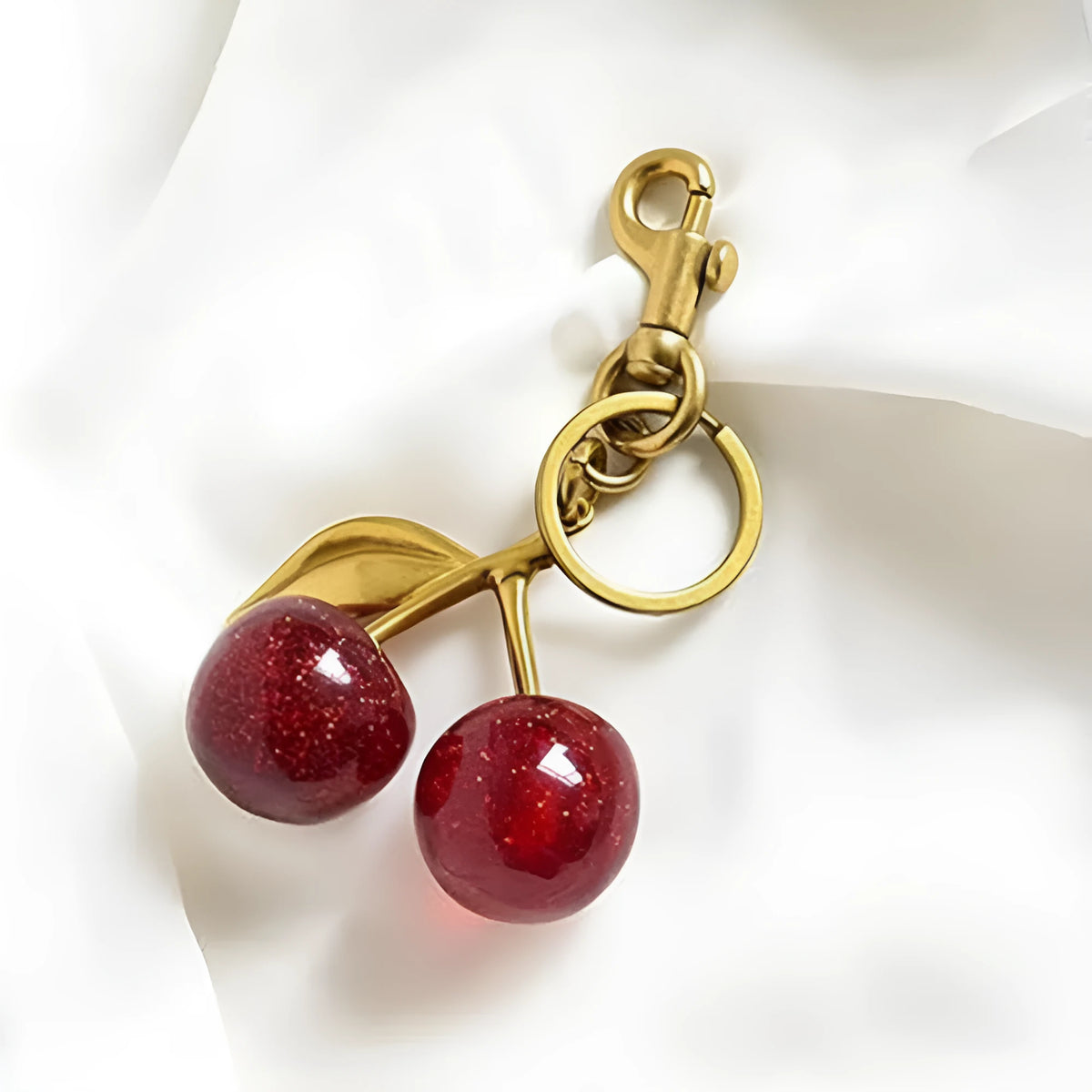 Red zinc alloy cherry-shaped keychain pendant on a key ring.