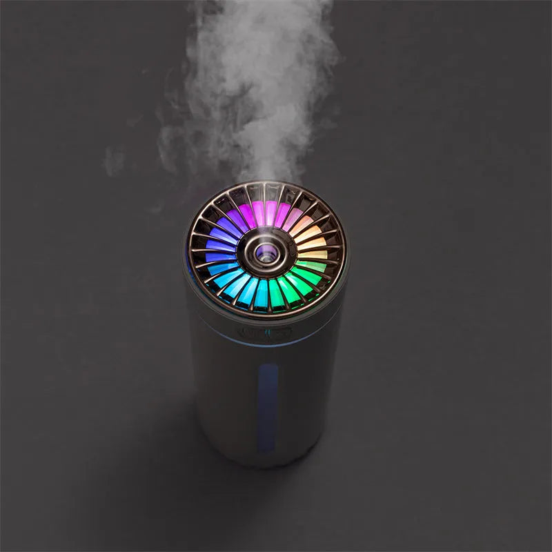 Black portable humidifier with LED lights beside car cup holder showing mist output