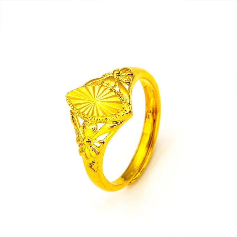 Geometric gold brass ring with open floral cut-out design and textured band, shown from the side.