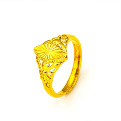 Geometric gold brass ring with open floral cut-out design and textured band, shown from the side.