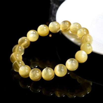 Yellow golden dragon mica round beads bracelet with polished geometric beads on a string.