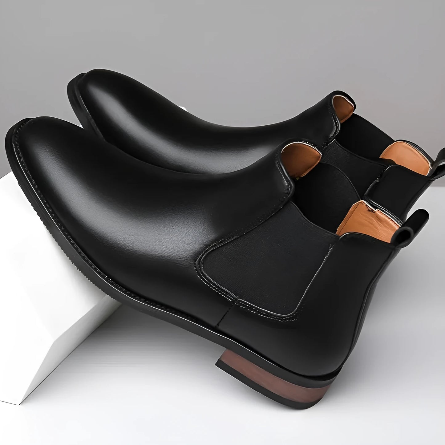 Men's black Chelsea boots with pointed toe design and sewing thread detailing on artificial PU upper