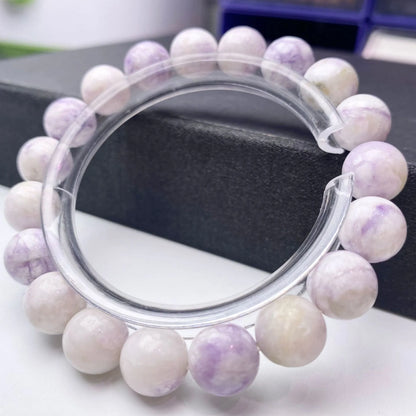 Close-up of a purple turquoise gemstone bead bracelet with an adjustable leather cord fastening.