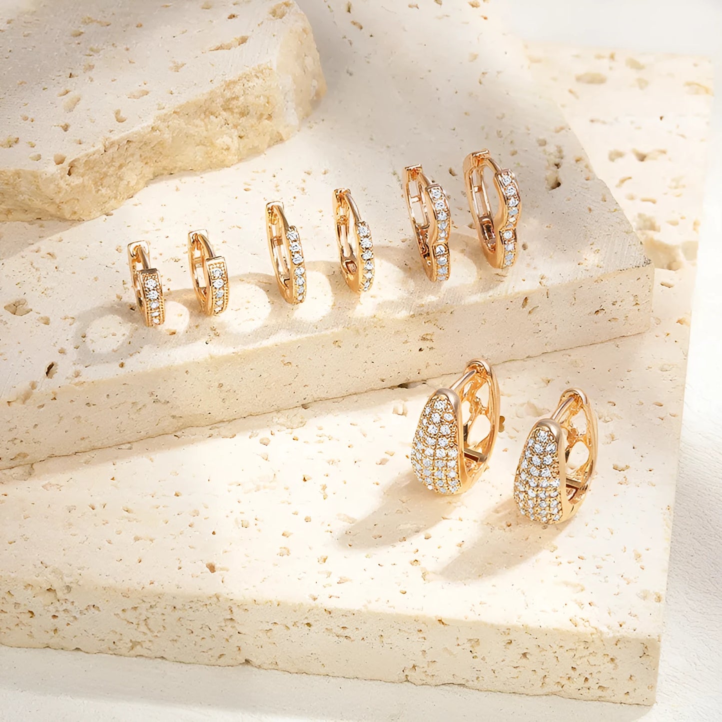 Gold plated heart-shaped clip-on earrings with multiple sparkling zircon stones on a white background.