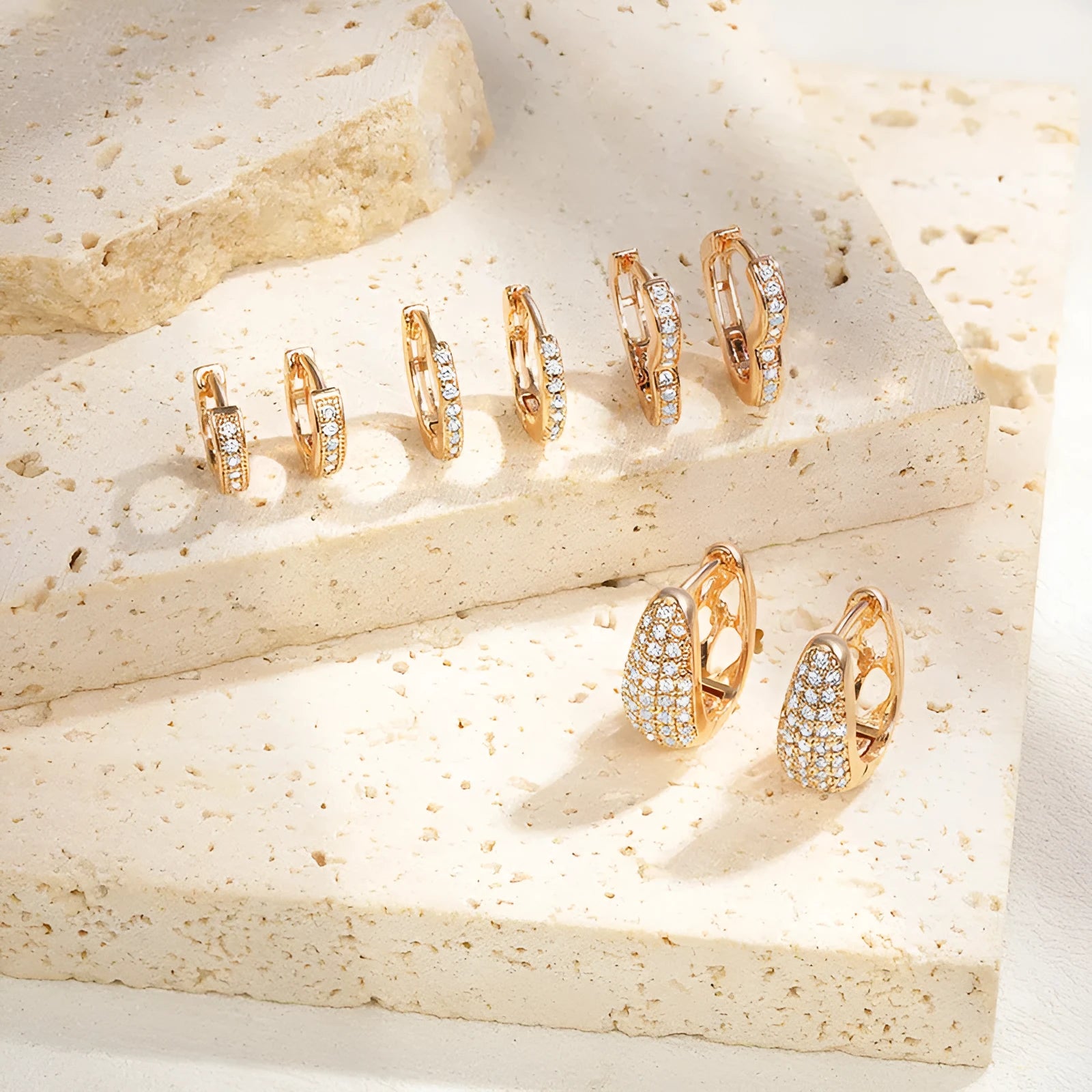 Gold plated heart-shaped clip-on earrings with multiple sparkling zircon stones on a white background.