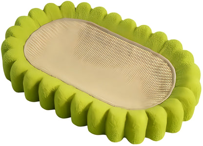 Green oval sisal cat scratching pad and lounge bed on a wooden floor.