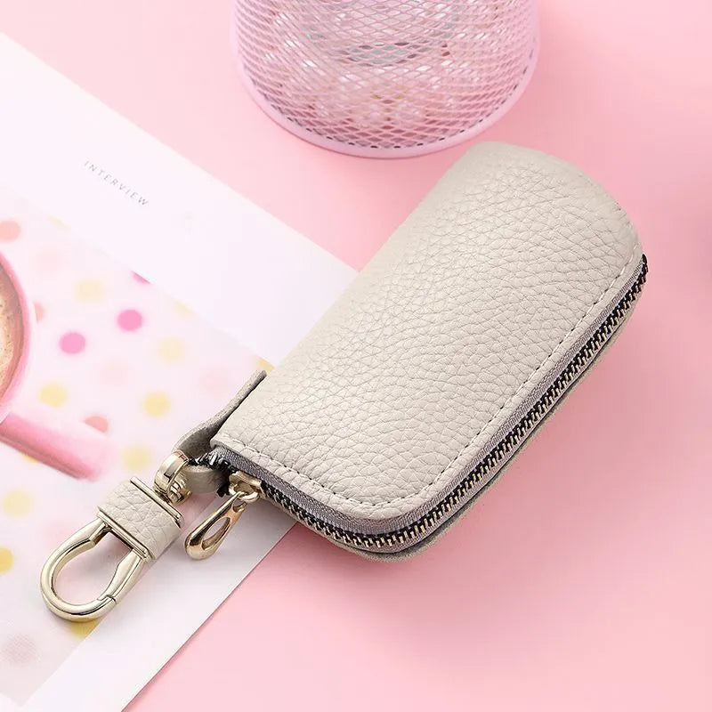 Minimalist black PU leather key wallet with a silver metal zipper closure.