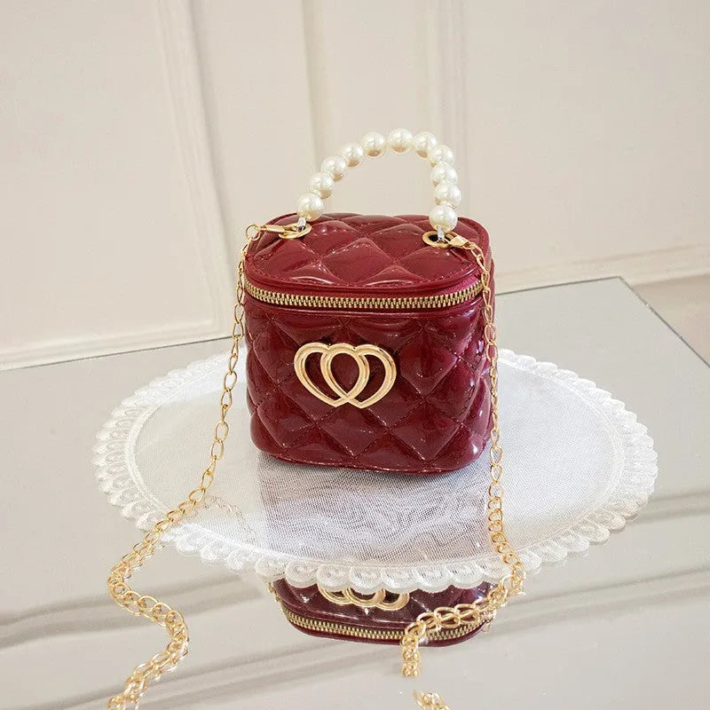 White PVC women's bucket bag with a heart-shaped pattern and shoulder strap.