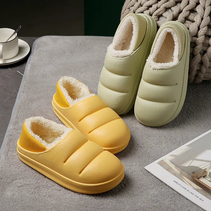 Pair of yellow waterproof EVA slippers with plush lining and a textured non-slip sole on a wooden floor.