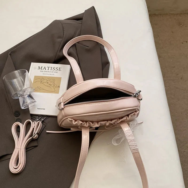 Women's PU leather casual shoulder handbag with a large bandage bow and sewing thread detail.