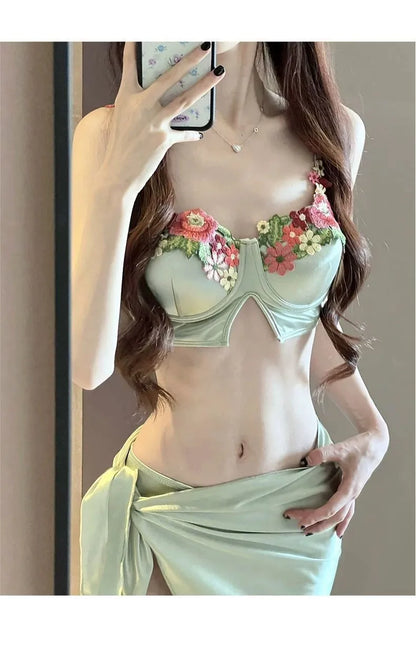 Green women's bikini three-piece set with triangle top, pants, and skirt
