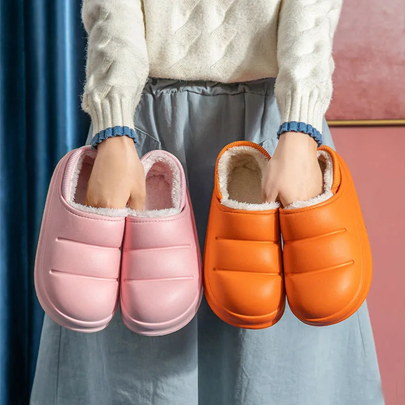 Pair of yellow waterproof EVA slippers with plush lining and a textured non-slip sole on a wooden floor.