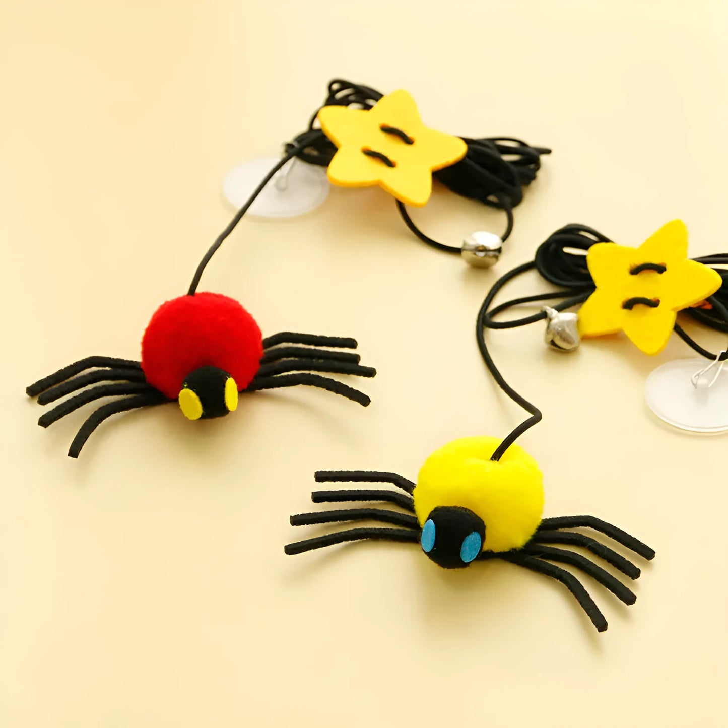 Red hanging door cat toy with elastic rope, feathers and spider-shaped bell mounted on door frame