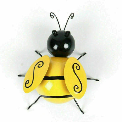 Four decorative metal bumble bee sculptures in a natural garden setting