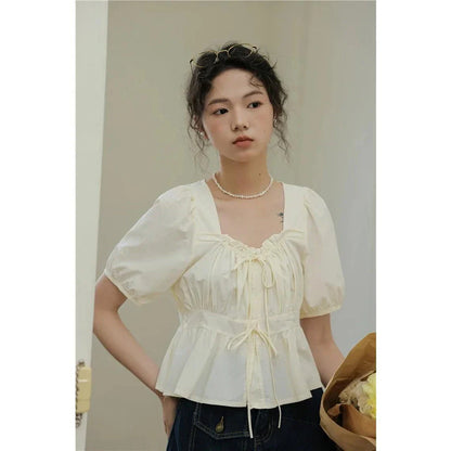 Elegant vintage white blouse with square neckline, puff sleeves, and lace-up detail