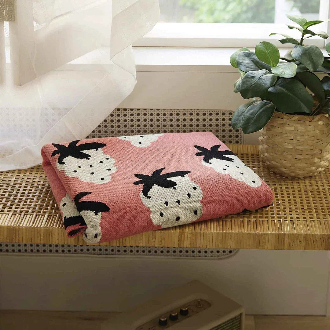 A cosy grape-patterned cotton blanket with a sophisticated design, perfect for relaxation and home decor