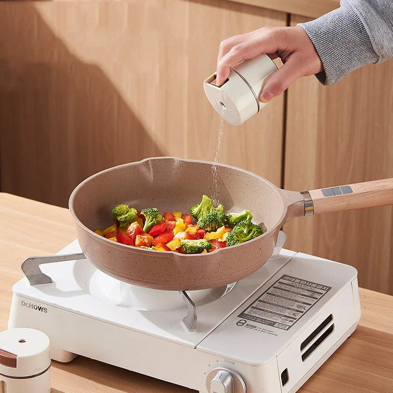 A modern, wall-mounted glass salt dispenser with magnetic suction and precise quantitative control for effortless kitchen organisation.