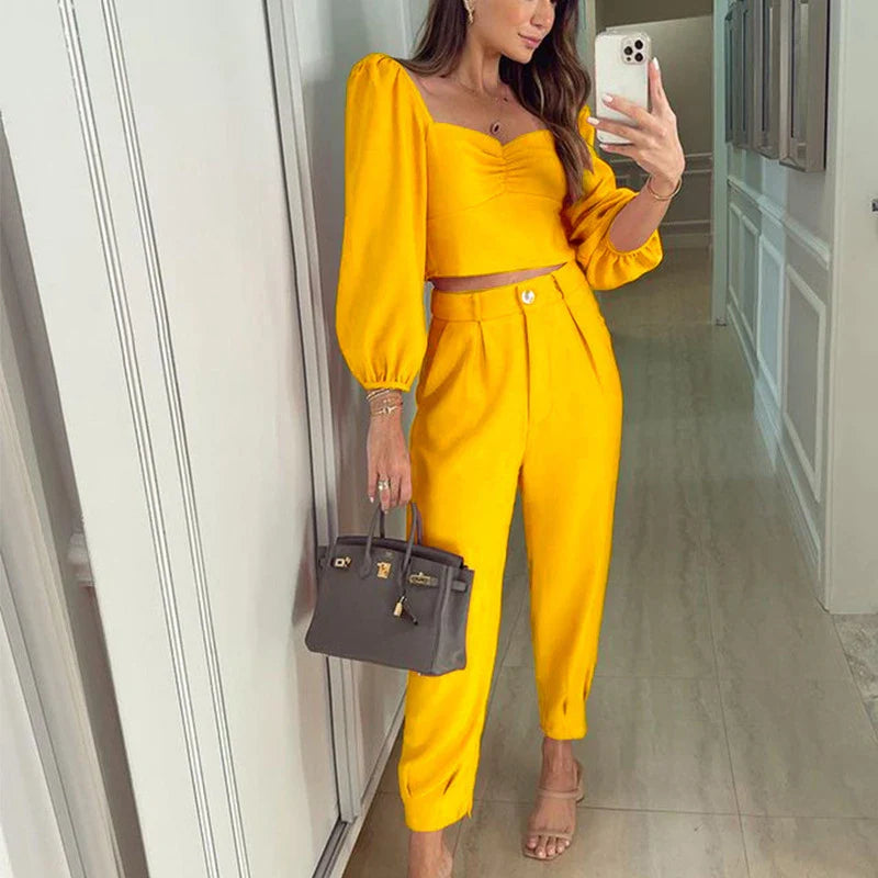 A stylish two-piece set with a square neckline top and ankle-tie trousers, made of premium polyester fabric and available in a range of vibrant solid colours.