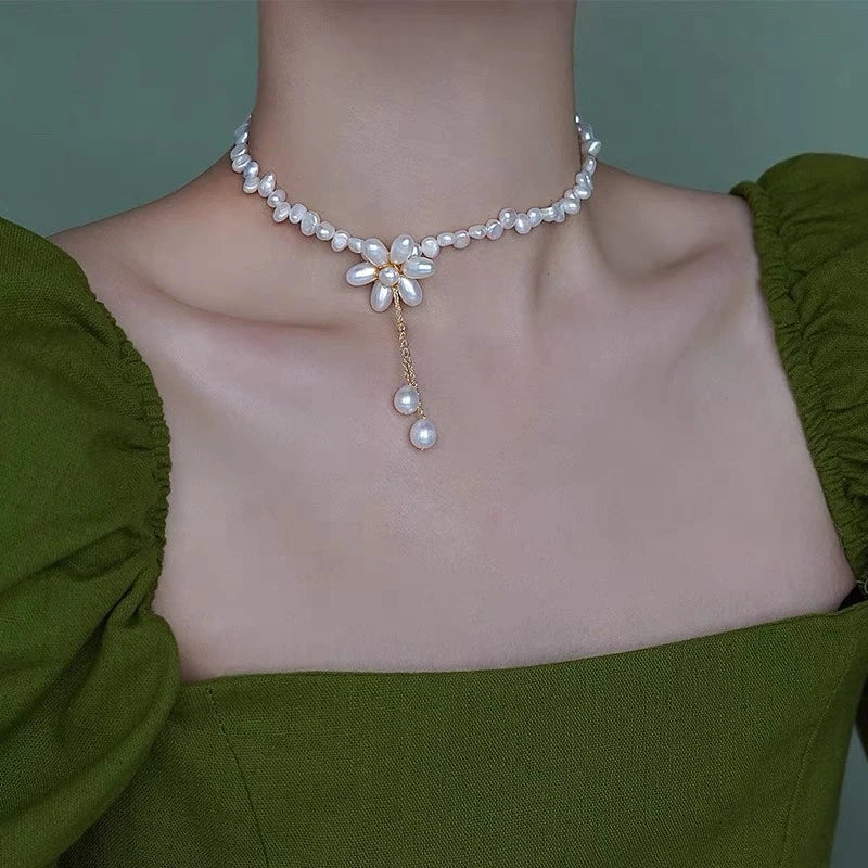 Elegant freshwater pearl necklace with intricate butterfly, dragonfly, and insect-inspired design on a copper-plated 14K gold chain