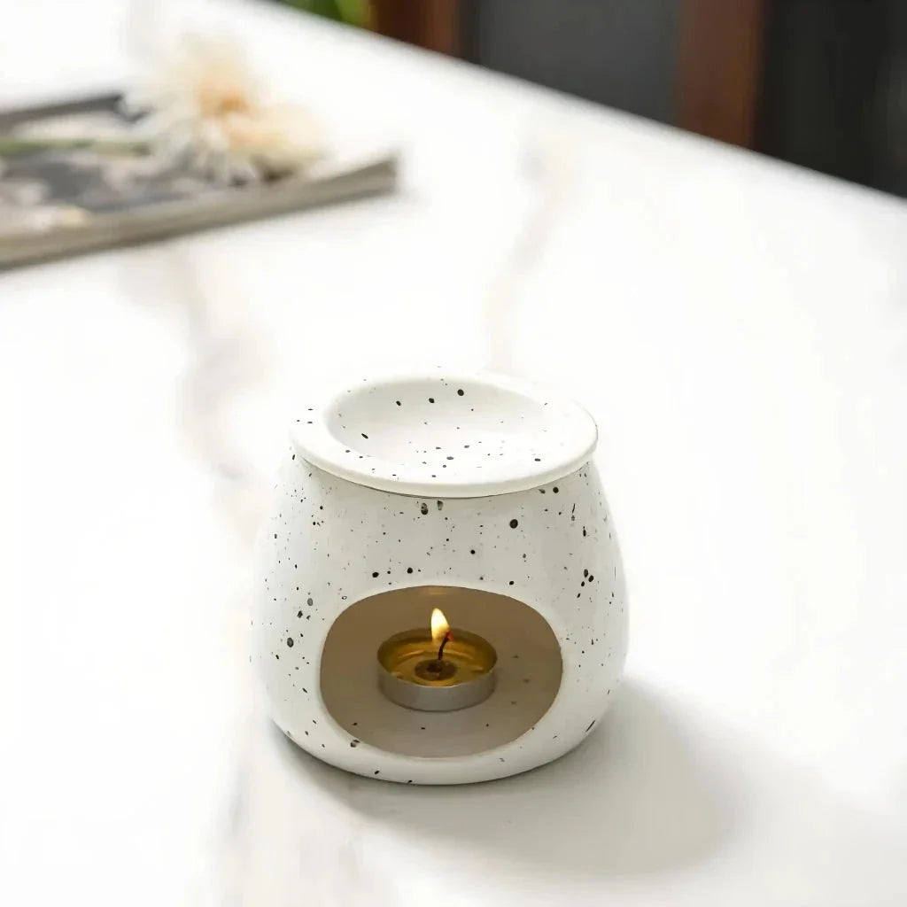 Elegant ceramic aroma diffuser with a unique spotted glaze design, perfect for creating a calming atmosphere in any room.