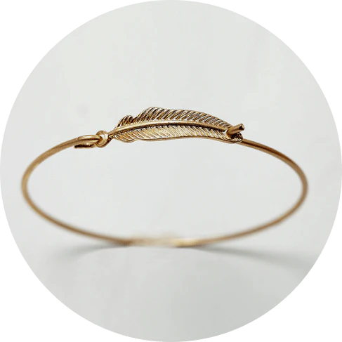 Elegant gold-coloured brass bracelet with a delicate falling leaf design, a nature-inspired accessory for everyday wear