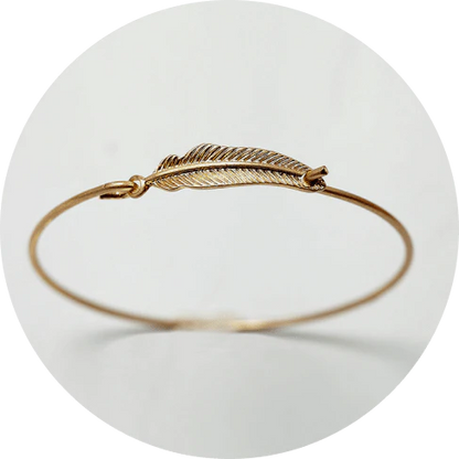 Elegant gold-coloured brass bracelet with a delicate falling leaf design, a nature-inspired accessory for everyday wear