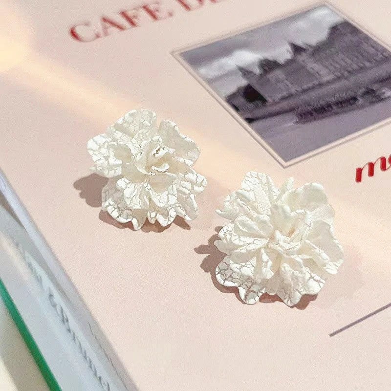Elegant white floral stud earrings with a unique and captivating design, perfect for fashion-forward women in the UK