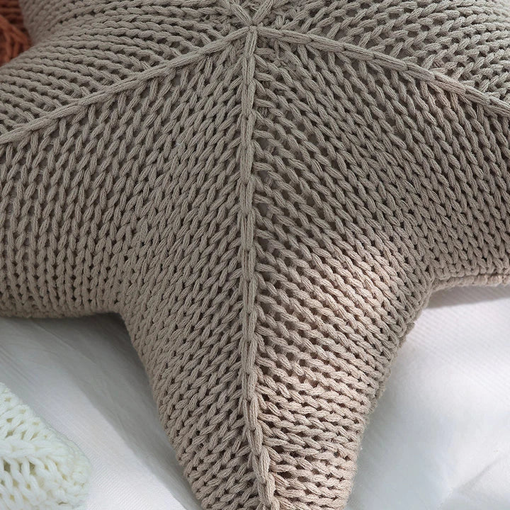 Artfully hand-knitted starfish-shaped cushion in a range of sophisticated colour options, providing plush comfort and coastal charm for any living space.