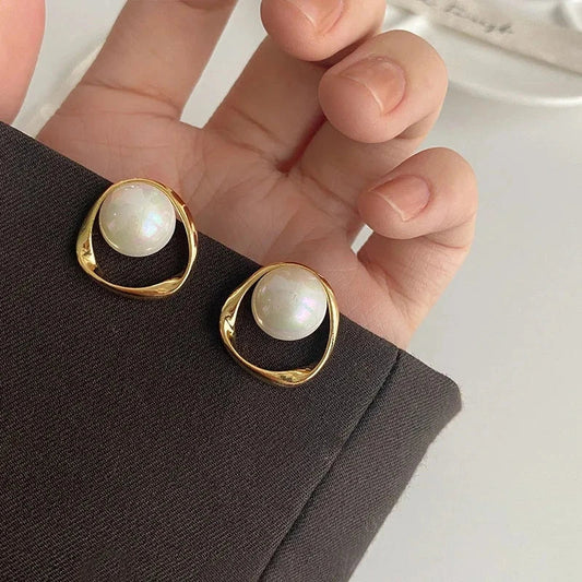 Elegant gold-coloured simulated pearl stud earrings with a distinctive geometric design