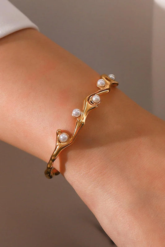 Elegant 18k gold-plated bracelet with shimmering synthetic pearls, showcasing a sleek, open design for a comfortable and stylish fit.