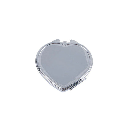 Heart-shaped metal pill box with built-in mirror for convenient storage and touch-ups on the go