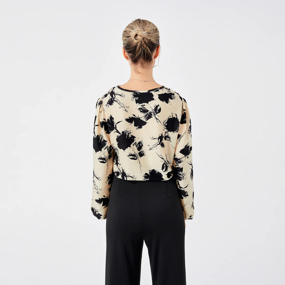 Elegant ladies' blouse with a printed pattern, dropped collar, and long sleeves in a classic white colour