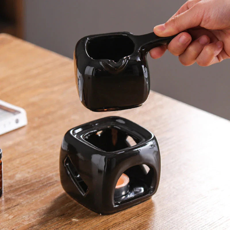 Elegant ceramic candle holder and tea warmer set in black, perfect for creating a cosy and relaxing atmosphere in your home.