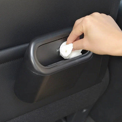 A compact black car bin with a press-type lid, designed to hang on the door panel and store garbage securely
