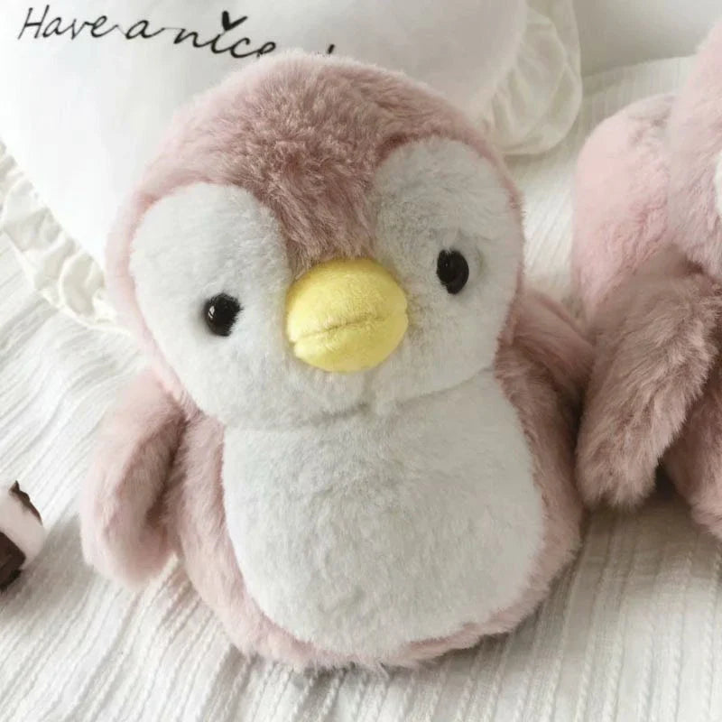 Pair of cosy, plush home slippers featuring a playful penguin design
