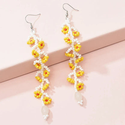 Elegant bohemian resin long tassel drop earrings in a vibrant yellow colour, featuring a mesmerising floral pattern and graceful movement