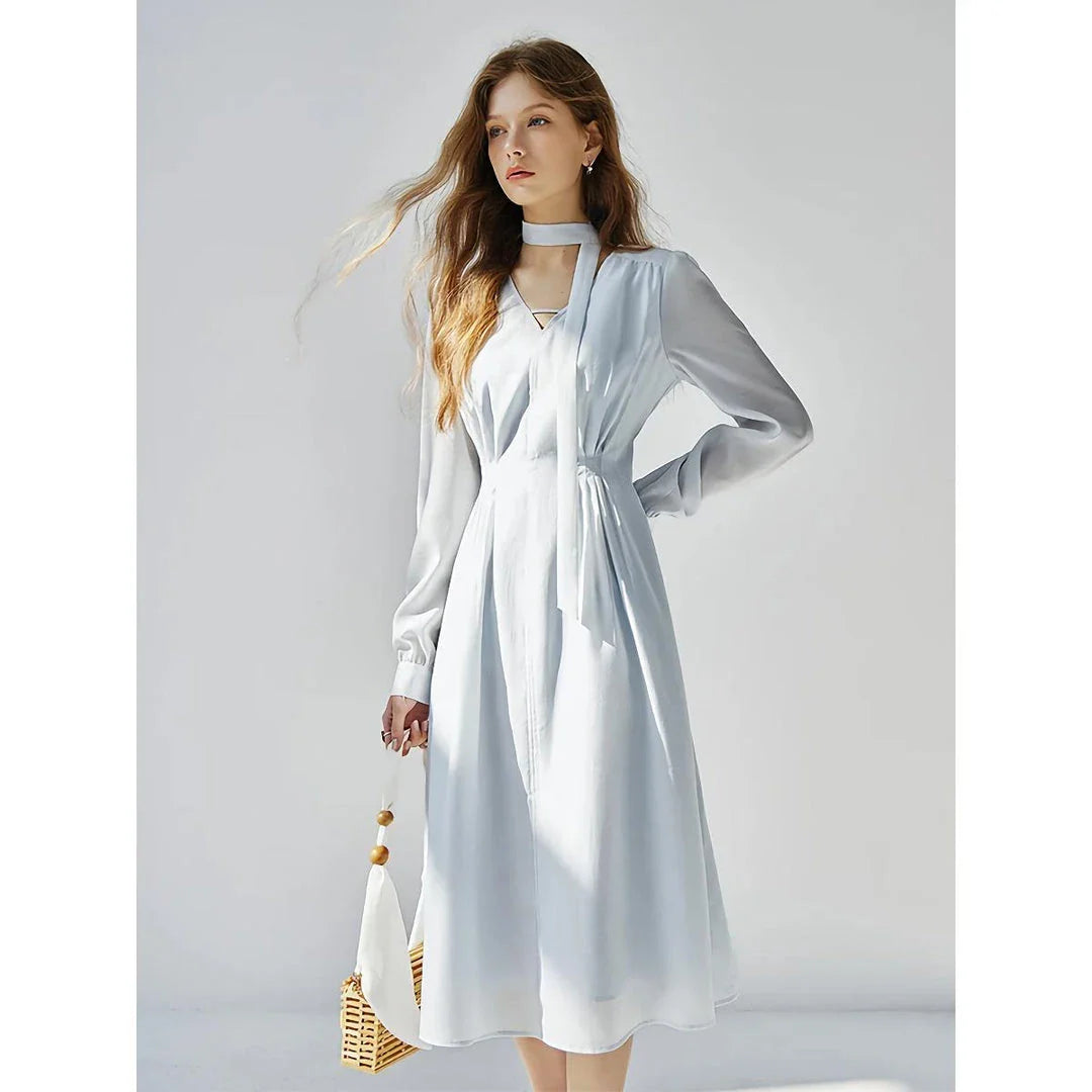 A light blue dress with a v-neck, puff sleeves, and a ribbon detail at the waist