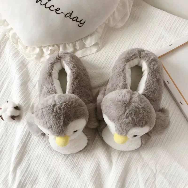 Pair of cosy, plush home slippers featuring a playful penguin design