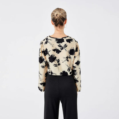 Elegant ladies' blouse with a printed pattern, dropped collar, and long sleeves in a classic white colour