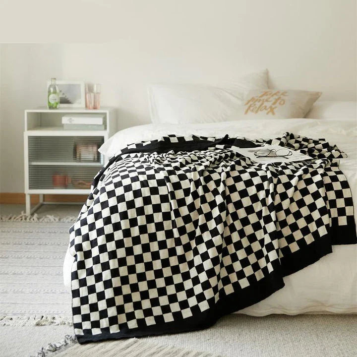 Cosy checkerboard plaid cotton knitted blanket in earthy tones of green, khaki, and black for stylish home decor