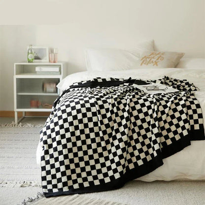 Cosy checkerboard plaid cotton knitted blanket in earthy tones of green, khaki, and black for stylish home decor