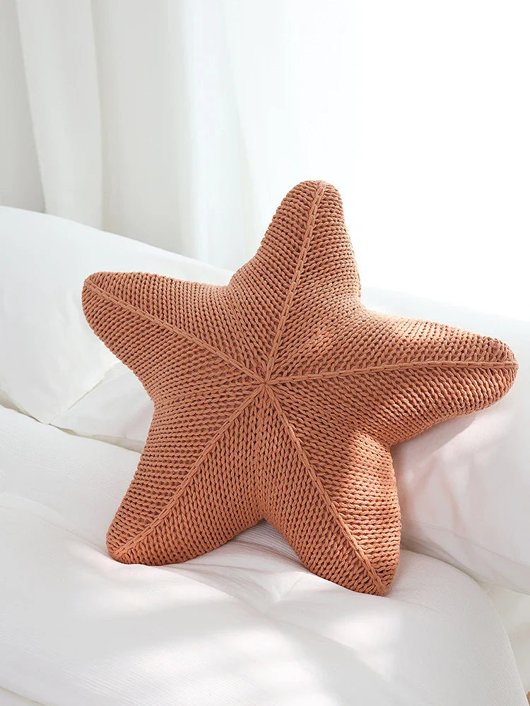 Artfully hand-knitted starfish-shaped cushion in a range of sophisticated colour options, providing plush comfort and coastal charm for any living space.