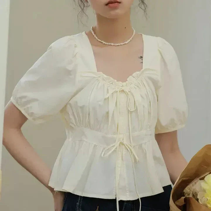 Elegant vintage white blouse with square neckline, puff sleeves, and lace-up detail