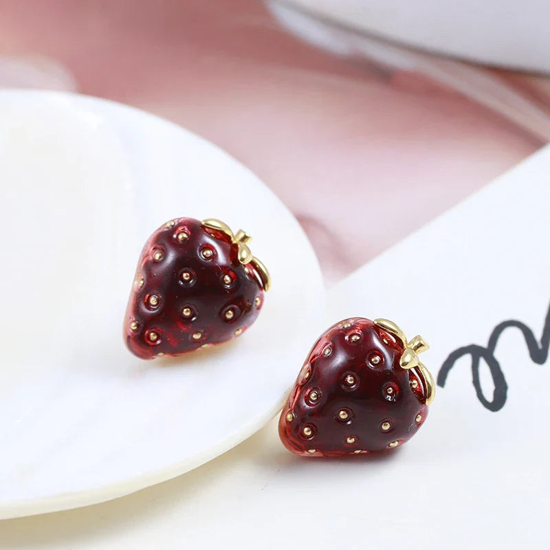 Pair of red resin strawberry stud earrings with a three-dimensional design and secure backing