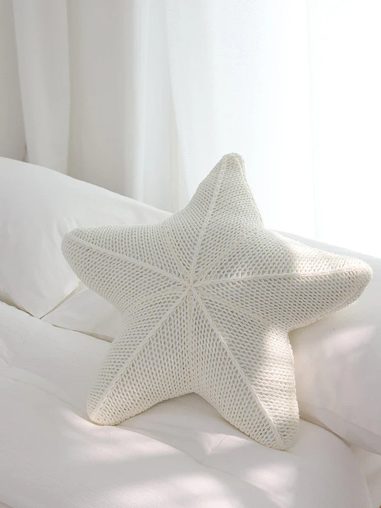 Artfully hand-knitted starfish-shaped cushion in a range of sophisticated colour options, providing plush comfort and coastal charm for any living space.