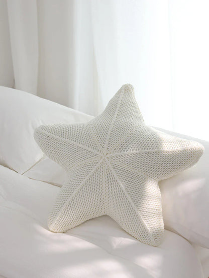 Artfully hand-knitted starfish-shaped cushion in a range of sophisticated colour options, providing plush comfort and coastal charm for any living space.